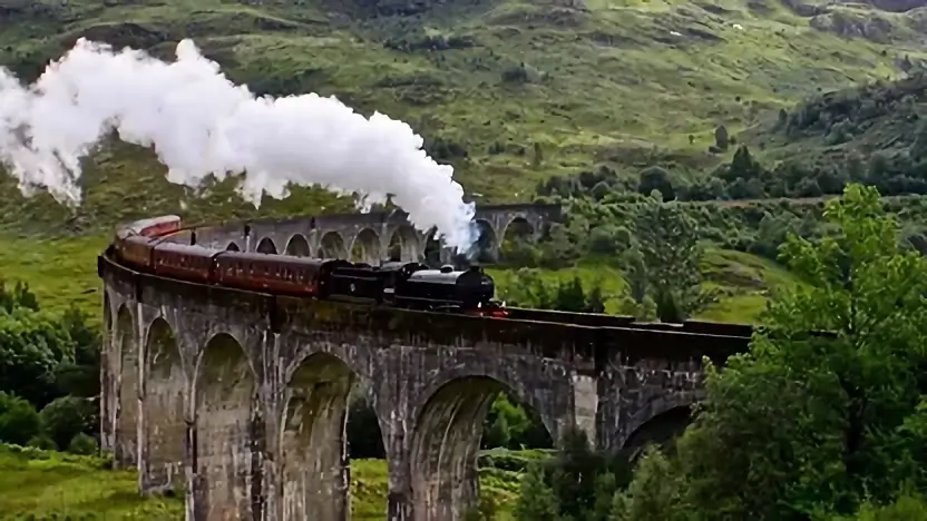 Viadotto di Glenfinnan con un treno che attraversa, famoso come percorso del treno di Hogwarts nei film di Harry Potter.