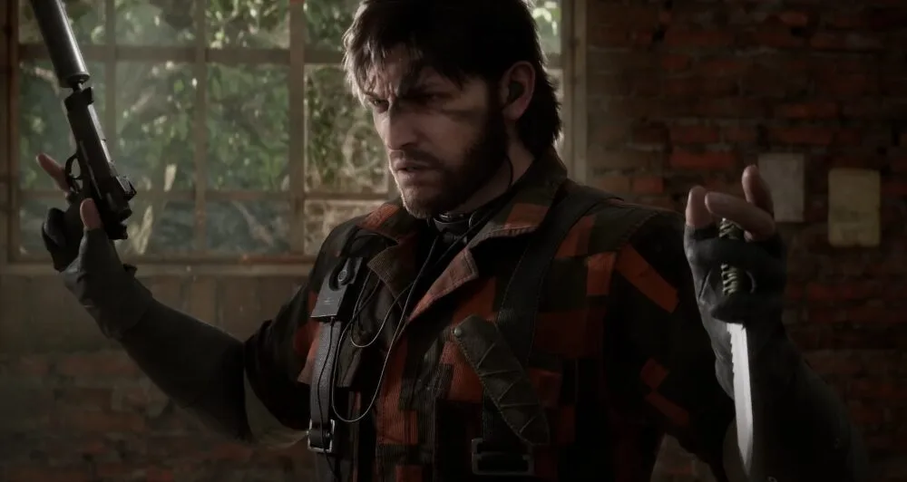 Snake di Metal Gear Solid Delta: Snake Eater dal trailer d Konami con il viso concentrato, impugnando una pistola con silenziatore e un coltello, immerso in un ambiente diroccato nel cuore della giungla.