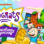 I personaggi di Rugrats, Tommy, Chuckie, Angelica e Reptar, in un'avventura cartoon nel deserto con un gettone dorato, nel gioco Rugrats Adventures in Gameland.