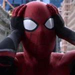 Spider-Man tiene le mani sulla testa in una scena iconica, circondato da grattacieli in una città.