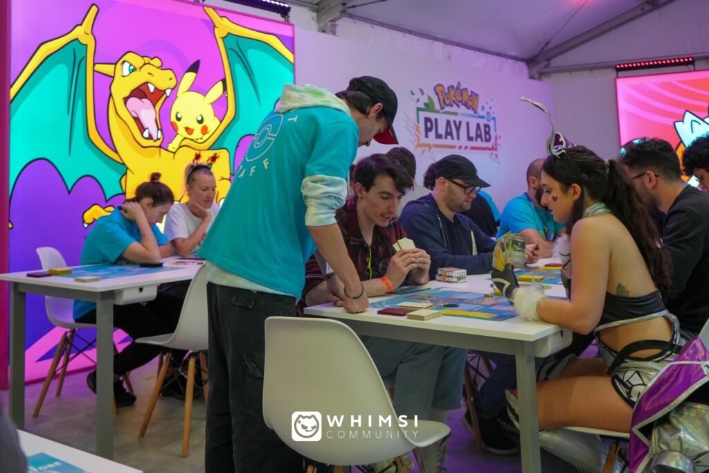Area Pokémon Play Lab alla Lucca Comics & Games 2024 con giocatori intenti a sfidarsi.