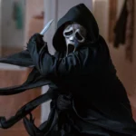 Ghostface brandisce un coltello in un'ambientazione domestica, pronto ad attaccare in Scream 7.